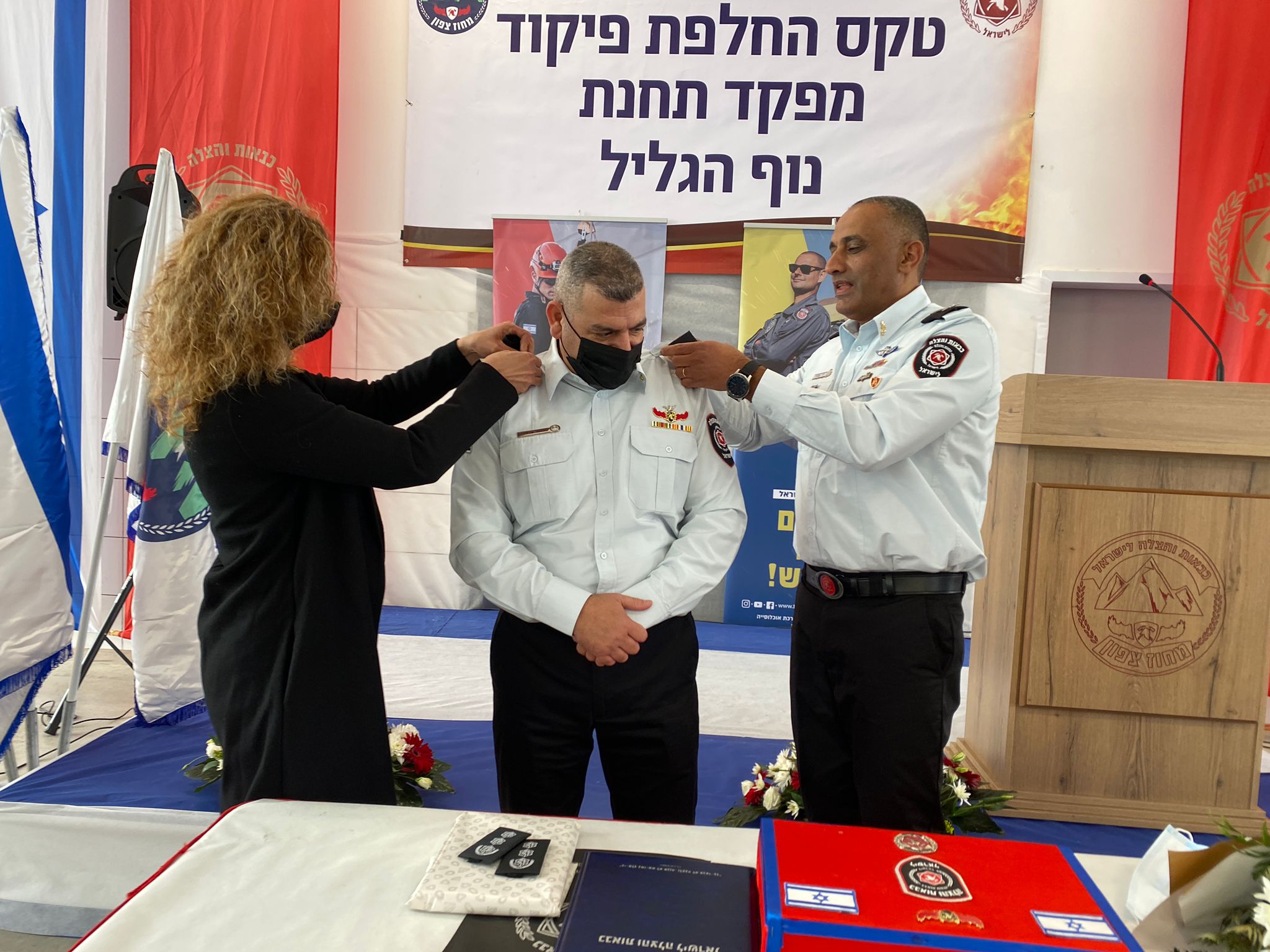 נציב כבאות והצלה לישראל, רב טפסר דדי שמחי, מעניק לטפסר משנה אדרי את הדרגה, יחד עם ענת, רעייתו של אדרי. צילום: יקיר נבון/כב״ה צפון